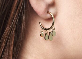 Die Steck-Kreole Elsa lässt goldene Plättchen an ihren Rundungen pendeln.